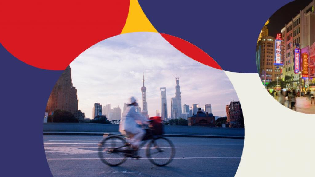 A person riding a bicycle on a street with a city in the background.